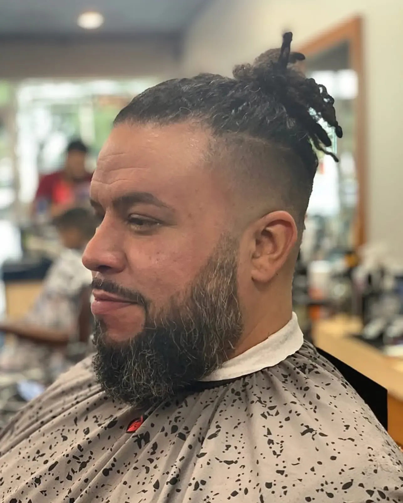 Clean taper with locs tied up, beard detailed