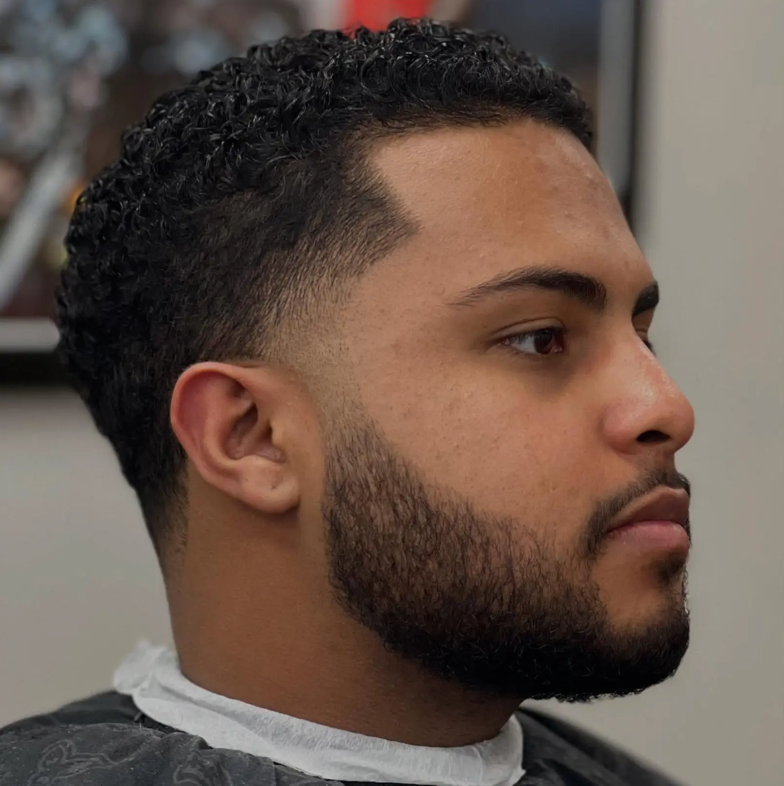 Low fade with a textured curly top, fresh line-up