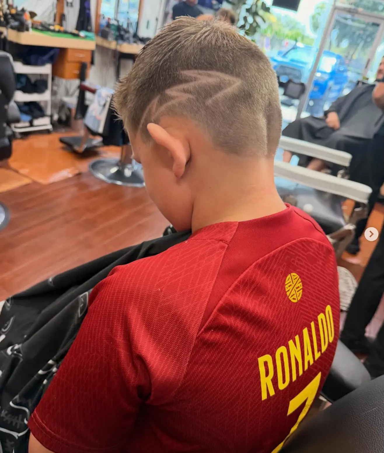 Kids cut with a shaved design in the barber chair